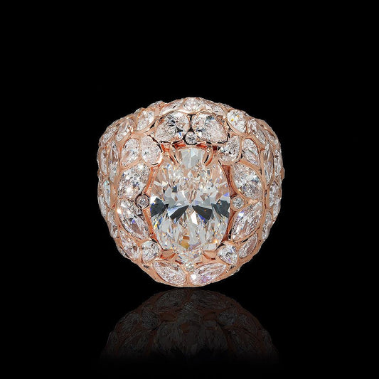 May include: A rose gold ring featuring a large oval-cut diamond as the centerpiece. The ring is surrounded by a halo of smaller diamonds, with additional diamonds set along the band, creating a cluster effect. The diamonds sparkle against a black background.
