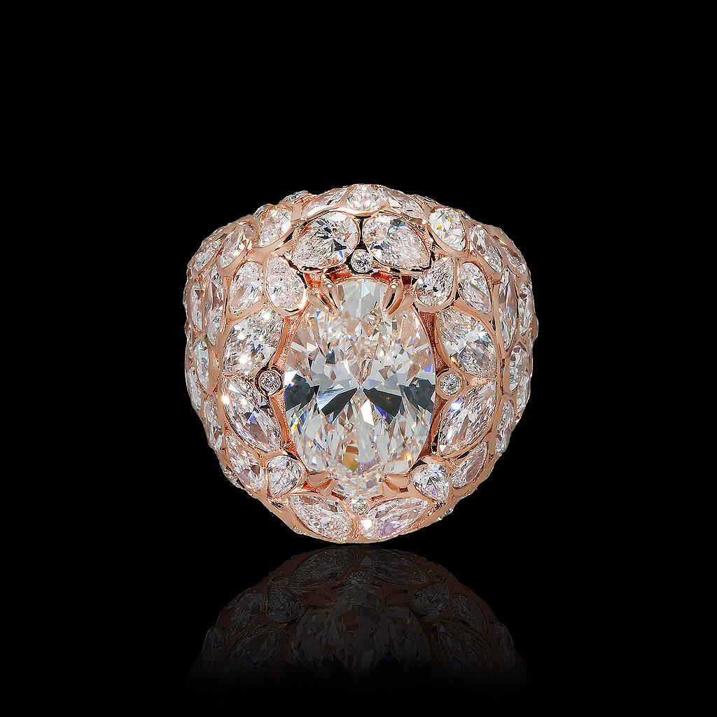 May include: A rose gold ring featuring a large oval-cut diamond as the centerpiece. The ring is surrounded by a halo of smaller diamonds, with additional diamonds set along the band, creating a cluster effect. The diamonds sparkle against a black background.